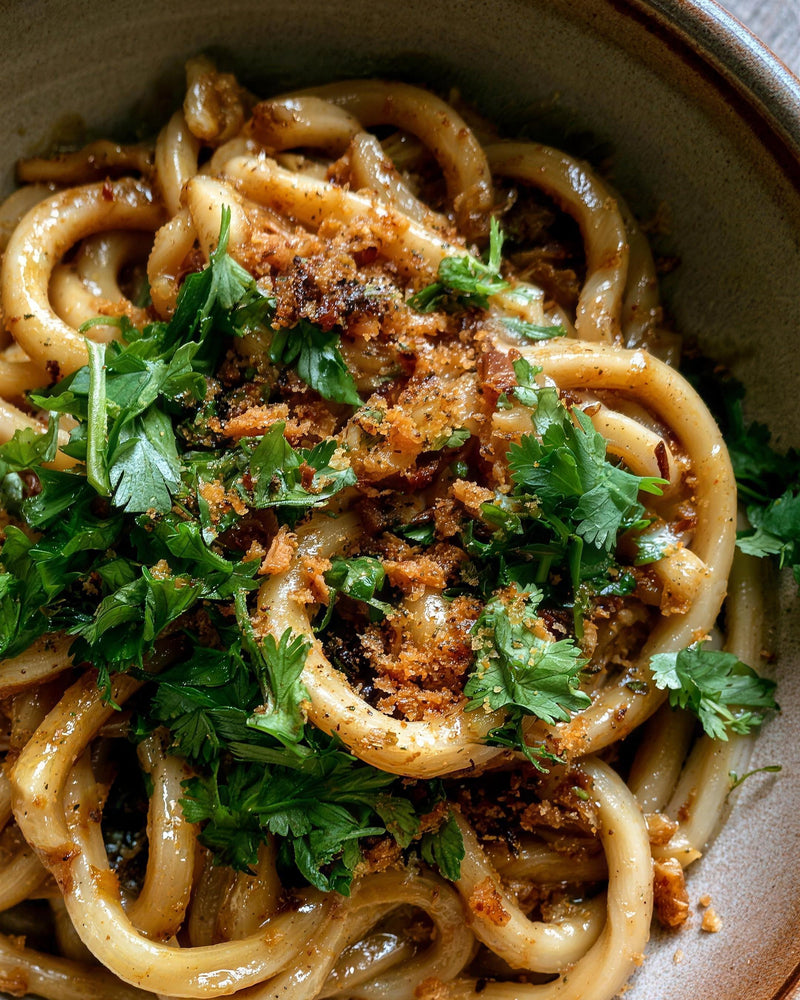 A bowl of low carb Thai green curry noodles topped with fresh coriander and crispy fried shallots